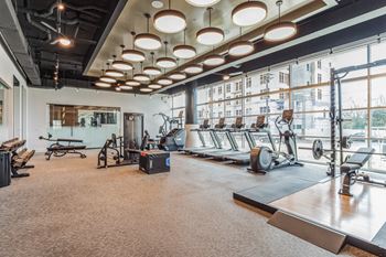 A gym with exercise equipment and large windows